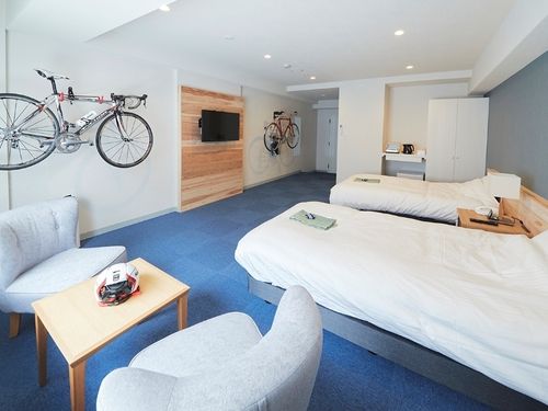 ゆったり広々とした客室。テレビボード・ヘッドボードは村産材を使用。全室サイクリングラック完備。