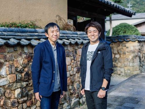 町役場の担当、志賀（左）と正司（右）です。いつでも相談してください！［トンバイ塀のある裏通り］
