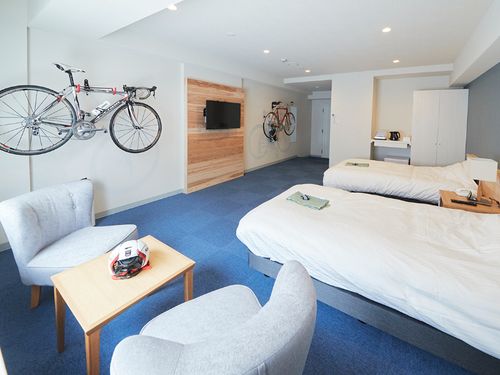 ゆったり広々とした客室。テレビボード・ヘッドボードは村産材を使用。全室サイクリングラック完備。