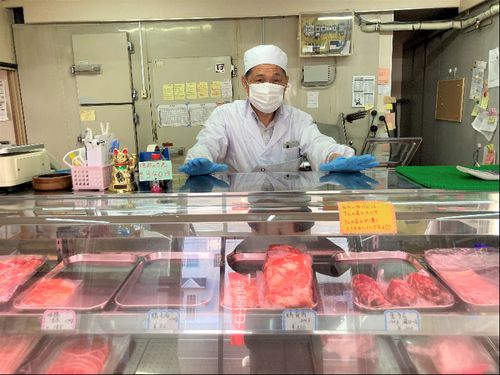 エプロン姿で店頭に立つ三津橋社長。