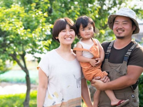 畑でほほ笑む千明さんとご家族