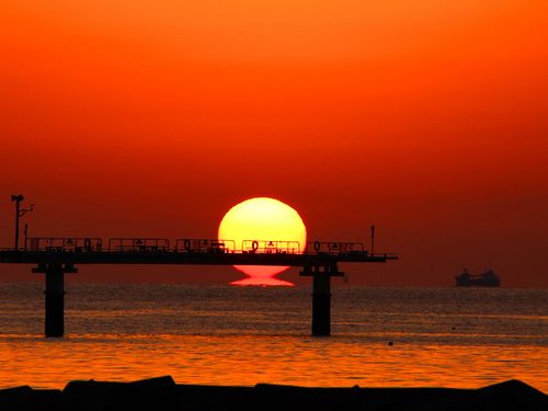 水平線に沈む太陽がだるまのような形にみえる「だるま夕日」（室積海岸・光市）