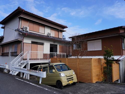 施設外観。ガレージのような空間の上に2階建ての家屋た建っています。