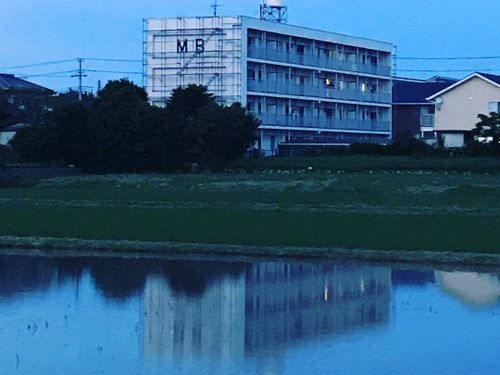 館山自動車道 富浦ICから車で7分。田んぼの向こうにそびえる4階建て。