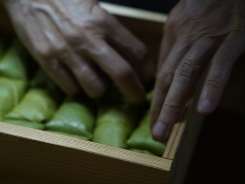 包んだ柿の葉寿司を大きい型に入れていくのですが、葉っぱが戻ろうとするのをなんとかしながら入れていきます。