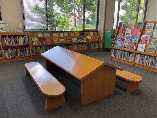 小さなお子さんでも絵本を選びやすく、広げて読みやすいテーブルとチェアがあります。（秦荘図書館）