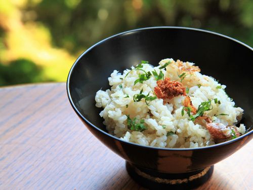 フグの卵巣をふりかけた鯛めしを漆器に盛る