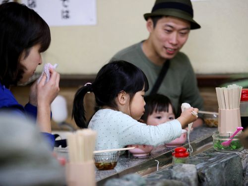 平家谷で流しそうめんを食べる家族