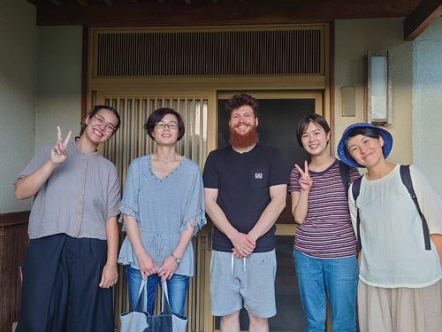体験住宅の玄関先で、住宅利用者と移住体験ツアー参加者で