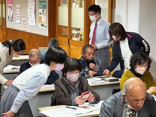 デジタル部の中学生が、地域の方にスマートフォンの使い方をサポートしています