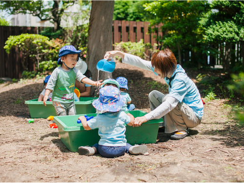 園庭で水遊び。大人が決めた「一斉遊び」はせず子どもが思い思いに遊びます