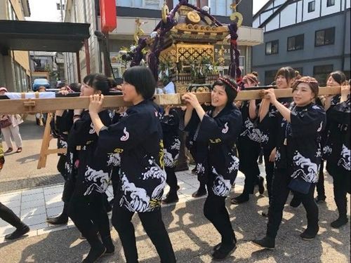 女性たちが協力して神輿を担ぎます