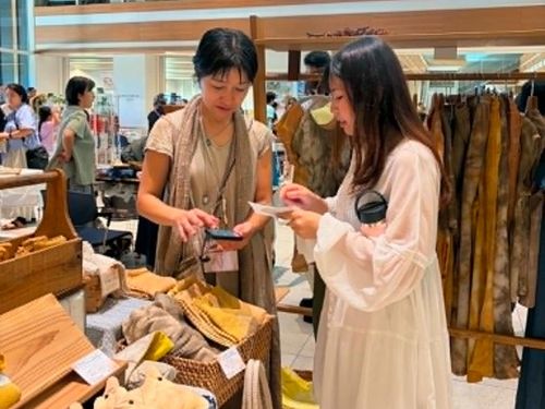 石垣島てづくり市で出展者とリネンを使ったコーヒー染めについてのやりとり