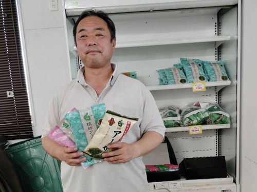 北中城村の特産品を手に取る長内氏