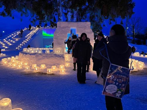 アイスキャンドルフェスティバルにて、来場者の写真撮影を行う中学生