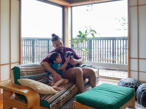 リフォームしたテラスを背景に、ガブさんと息子さんとワンちゃん。