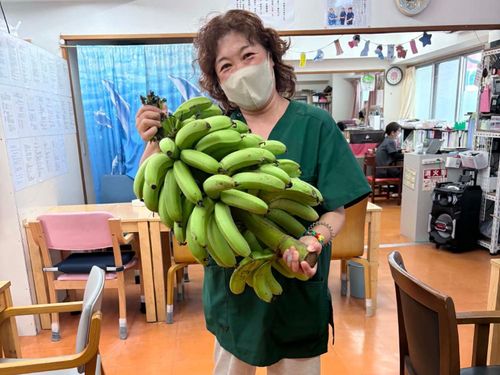 施設の利用者から初めて島バナナをもらって島の恵みを持つ大井川さん