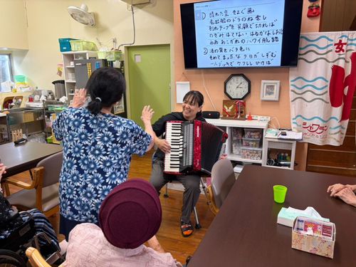 デイサービス「にぃふぁいゆー」でアコーディオンを演奏する仲里さん