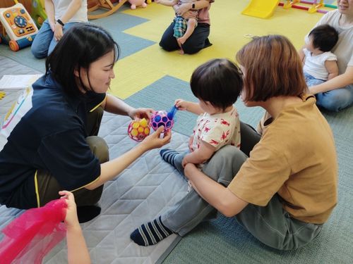 スカーフを摘まんで取り出す遊び。こどもの様子や興味に合わせた内容を考えている
