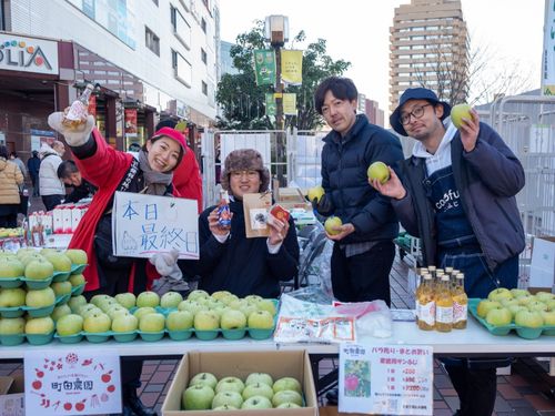 地元農家や行政と連携して首都圏物産イベントで出展サポートする隊員（写真左側２名）