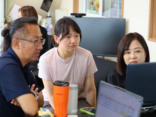 事務所での仕事風景　左から）荒木隊員、代隊員、樋口隊員