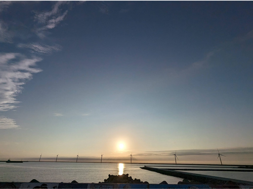 港湾区域の洋上風力発電と夕暮れ
