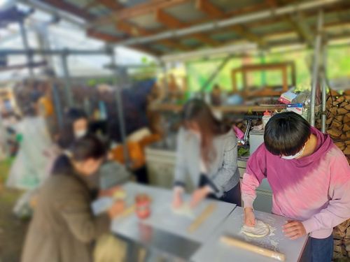 協力して生地を成形し、ピザを作っていきます