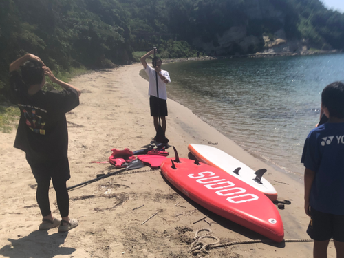 夏のひとコマ。島留学生にSUPをレクチャーするハウスマスター。それぞれの得意分野を活かして働いています。